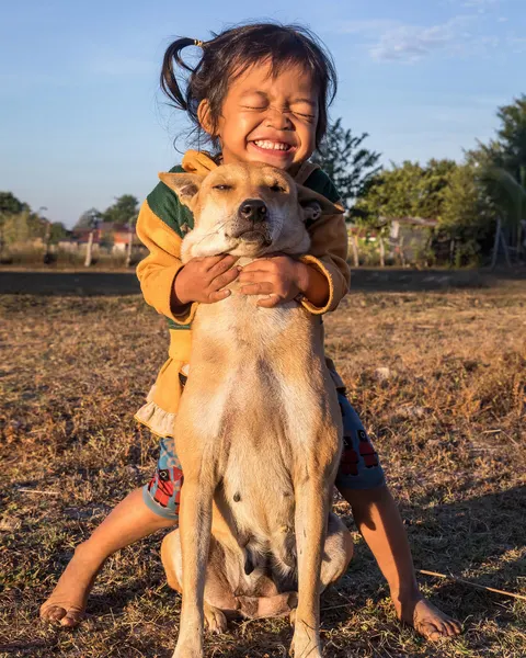 Ein Mädchen umarmt seinen Hund im Freien